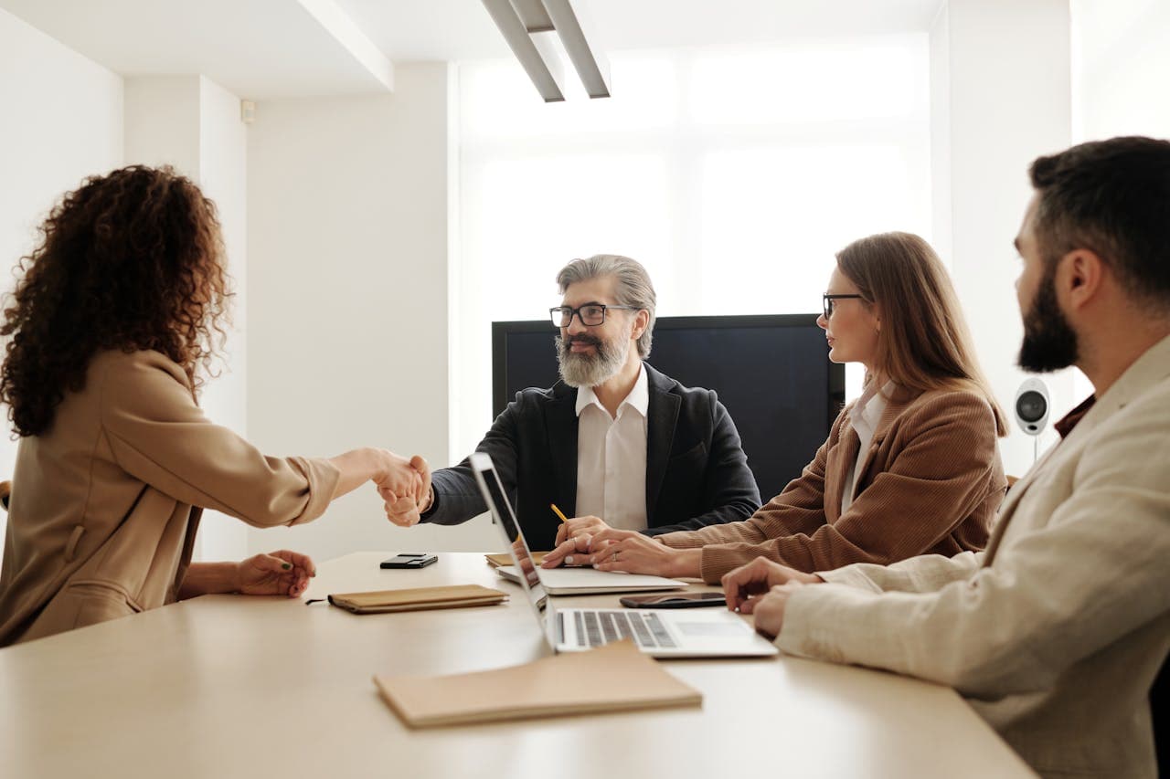 Colleagues celebrating a successful negotiation with a handshake in a modern office